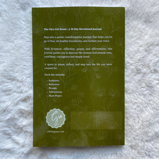 Green book titled 'The Nice Girl Reset' on a textured white surface