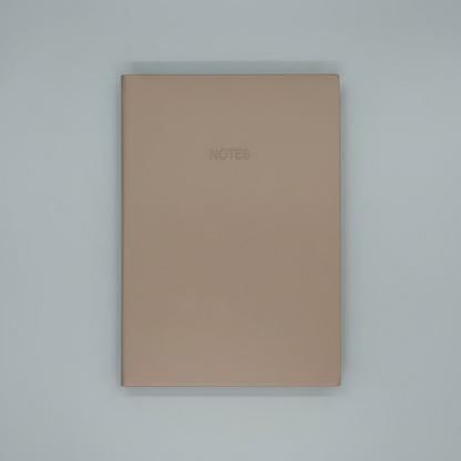 Beige notebook with 'NOTES' on a white surface with geometric black and white pattern